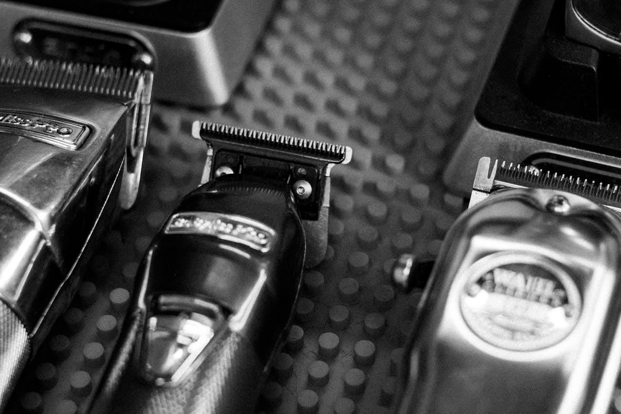 Black and white close-up of professional barber clippers on a textured surface.